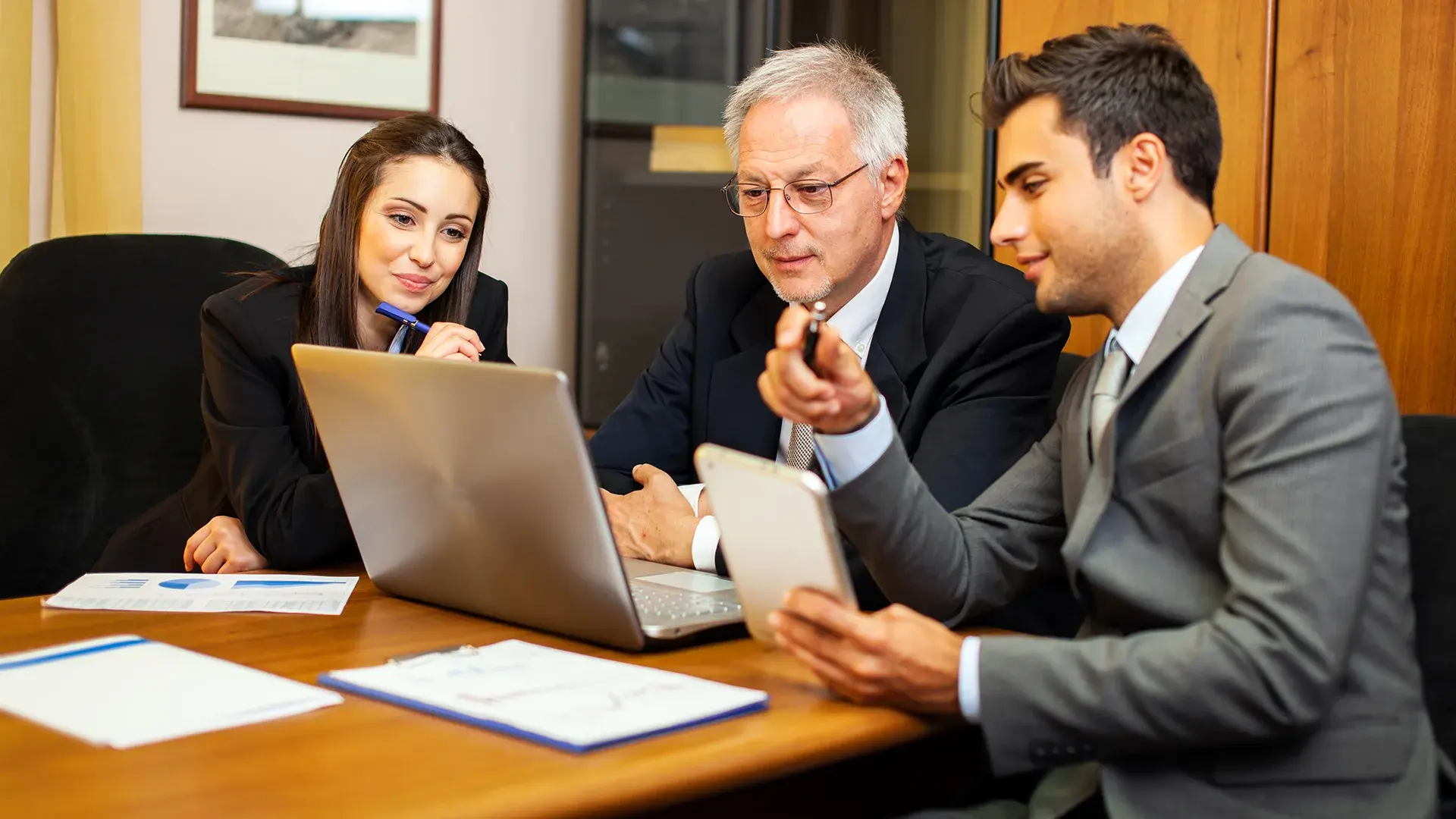 three officers discussing something in an office settings