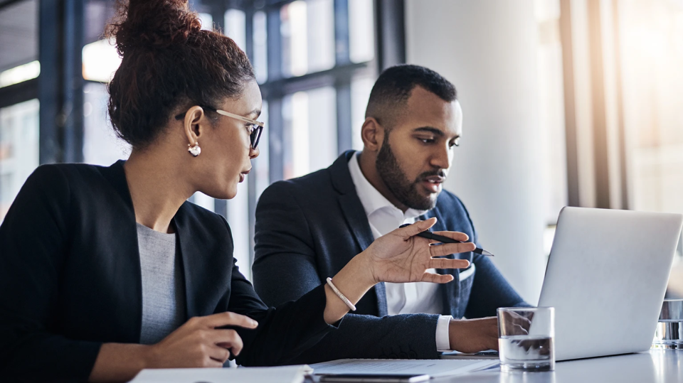 Two professionals reviewing information on a laptop during an internal investigation discussion
